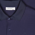 Nahaufnahme eines dunkelblau strukturierten J.Lindeberg Poloshirts (Größe M) mit sichtbarem Marken-Label, Polokragen und Knopfleiste