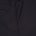 Detailaufnahme eines schwarzen Performance-Kleidungsstücks mit sichtbaren Nähten, Taschen und Markenlogo-Etikett