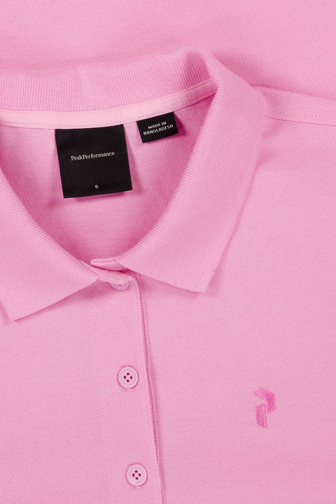 Nahaufnahme eines rosa Peak Performance Poloshirts in Größe S, hergestellt in Bangladesch, mit sichtbarem Kragen, Knöpfen und Marken-Etikett