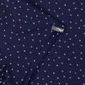 Nahaufnahme eines dunkelblauen Kleidungsstücks mit weißem Polka-Dot-Muster, zeigt den Reißverschluss und die Stofftextur