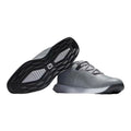 Graue und dunkelblaue Golfschuhe mit schwarzer Sohle, gezeigt in Seitenansicht und Sohlenansicht auf weißem Hintergrund