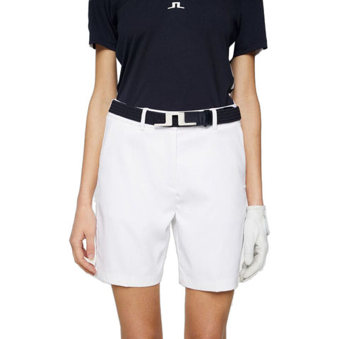 Weißes Golfshorts mit schwarzem Shirt und passendem Gürtel von J. Lindeberg