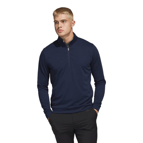 Junger Mann in marineblauem Langarm-Poloshirt mit halbem Reißverschluss und schwarzer Hose