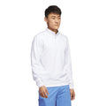 Mann trägt weißen Pullover mit Reißverschluss und blaue Shorts
