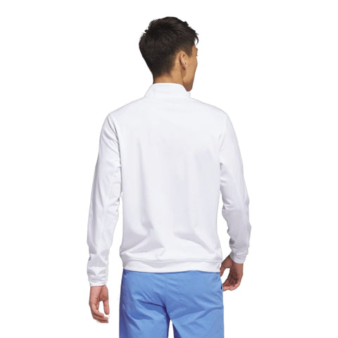 Rückansicht eines Mannes in weißem Jacke und blauer Hose vor neutralem Hintergrund