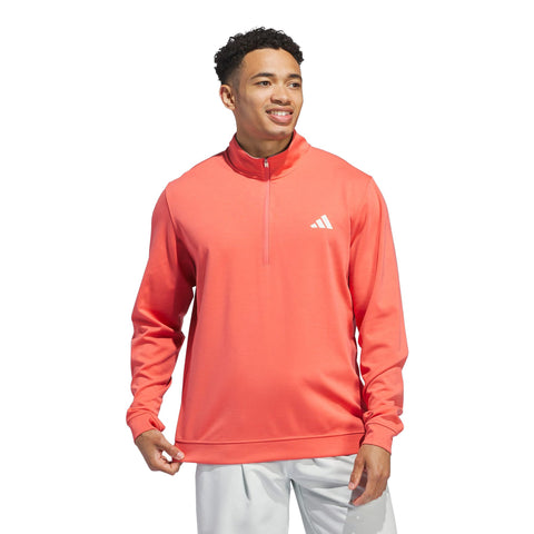Lächelnder Mann trägt einen korallenfarbenen Adidas Pullover mit halbem Reißverschluss