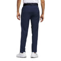 Dunkle Herrenhose von Adidas mit weißen Sportschuhen, von hinten fotografiert
